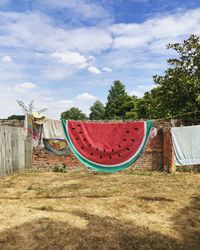 Clothes drying on field against sky