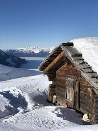 Built structure on snow covered mountain against sky