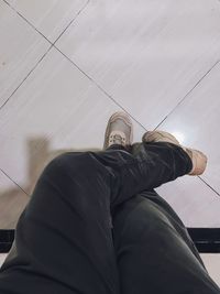 Low section of man sitting on tiled floor