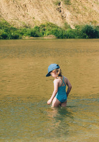 Child is standing in the water, going to swim in the lake. recreation and leisure in nature