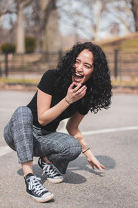 Happy of young woman crouching on road