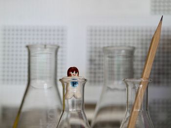 Close-up of conical flask with figuring and pencil