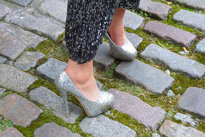 Low section of woman standing on footpath