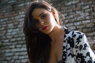 Portrait of woman standing against wall