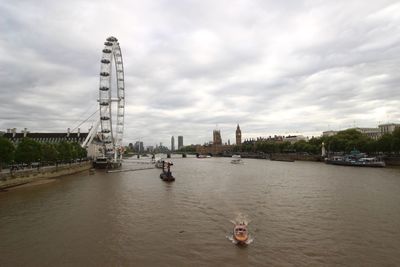 Scenic view of river by buildings against sky