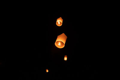 Low angle view of illuminated lantern against sky at night