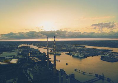 High angle view of buildings by sea against sky during sunset