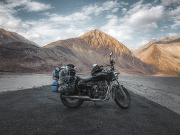 Motorcycle on road against mountain range