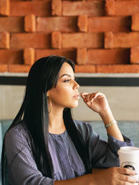 Woman thinking and looking somewhere, while having a coffee