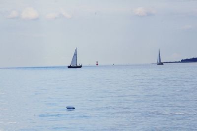 Boats sailing in calm sea against sky