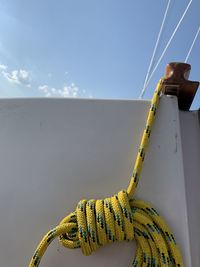 Close-up of rope tied on boat against sky