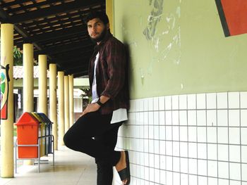 Portrait of man leaning on wall