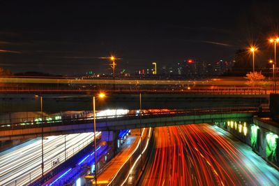 Light trails on bridge in city at night