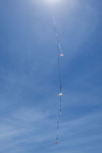 Low angle view of airplane flying against blue sky