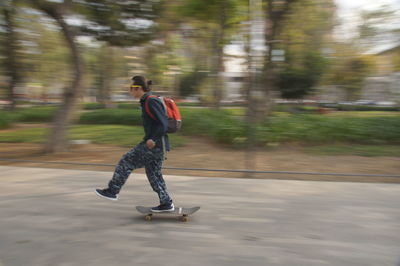 Full length of man skateboarding on road