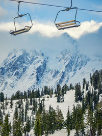 Overhead cable car over snowcapped mountains against sky