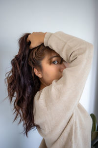 Close-up portrait of a young woman against white background