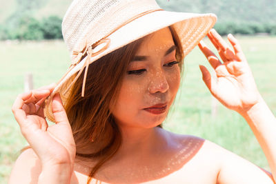 Close-up portrait of young woman wearing hat