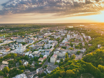 Aerial view of cityscape against cloudy sky during sunset