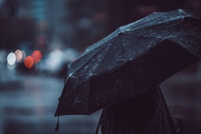 Close-up of person carrying umbrella during rainy season