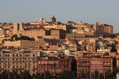 Buildings in city against clear sky