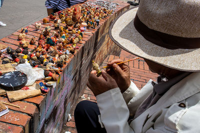 Bogota, colombia - july 2nd 2023. senior artisans selling pretty handmade birds made from seeds