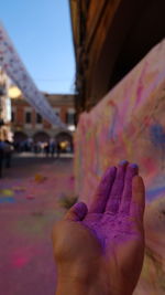 Cropped image of person powder paint against wall