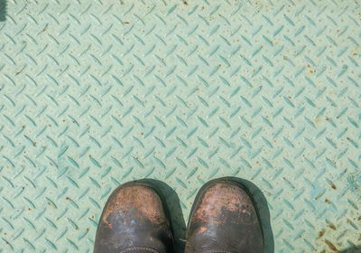 Low section of man standing on tiled floor