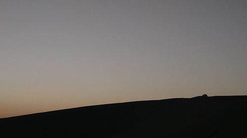 Low angle view of silhouette mountain against clear sky