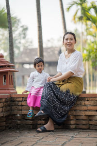 Portrait of mother and girl standing outdoors