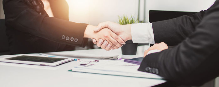 Midsection of couple holding hands on table