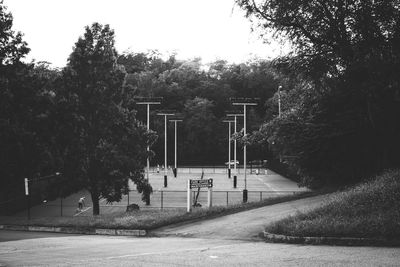 Footpath in park by city against sky