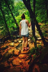 Rear view of woman walking in forest