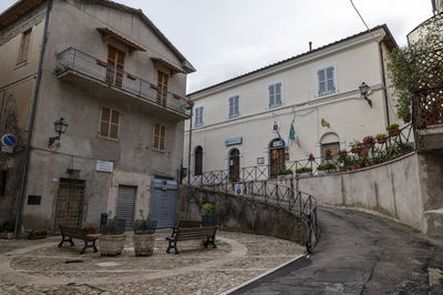 Houses by street in town against sky