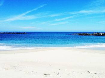 Scenic view of beach against blue sky