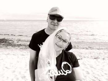 Portrait of smiling couple standing at beach