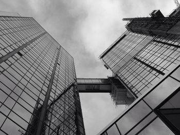 Low angle view of modern buildings against cloudy sky