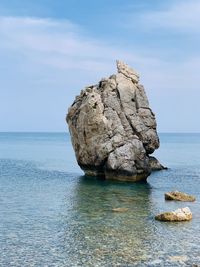 Rock formation in sea against sky