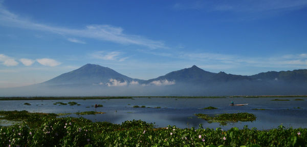 Scenic view of sea and mountains against sky