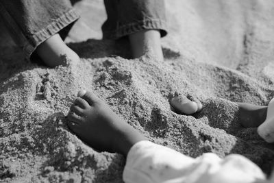 Low section of people on sand at beach