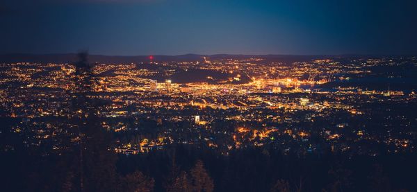 Illuminated cityscape against sky at night