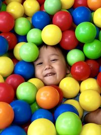 Full length portrait of smiling boy in colorful balas pool. 