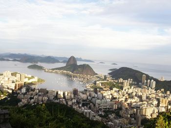 Aerial view of city against cloudy sky