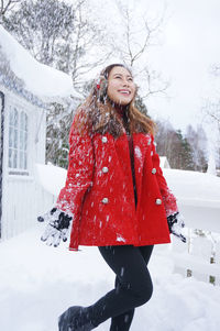 Young woman wearing warm clothes in winter during snowfall