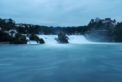 Scenic view of waterfall against sky