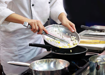 Midsection of man preparing food in kitchen