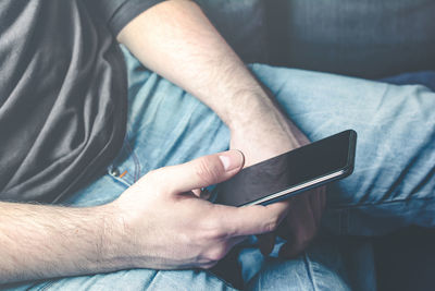 Midsection of man using mobile phone