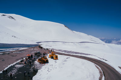 Scenic view of snowcapped mountains against clear blue sky