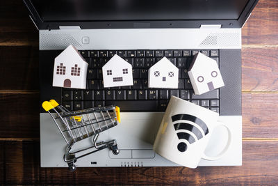 High angle view of laptop and shopping cart on table