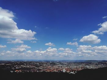 Aerial view of cityscape against blue sky